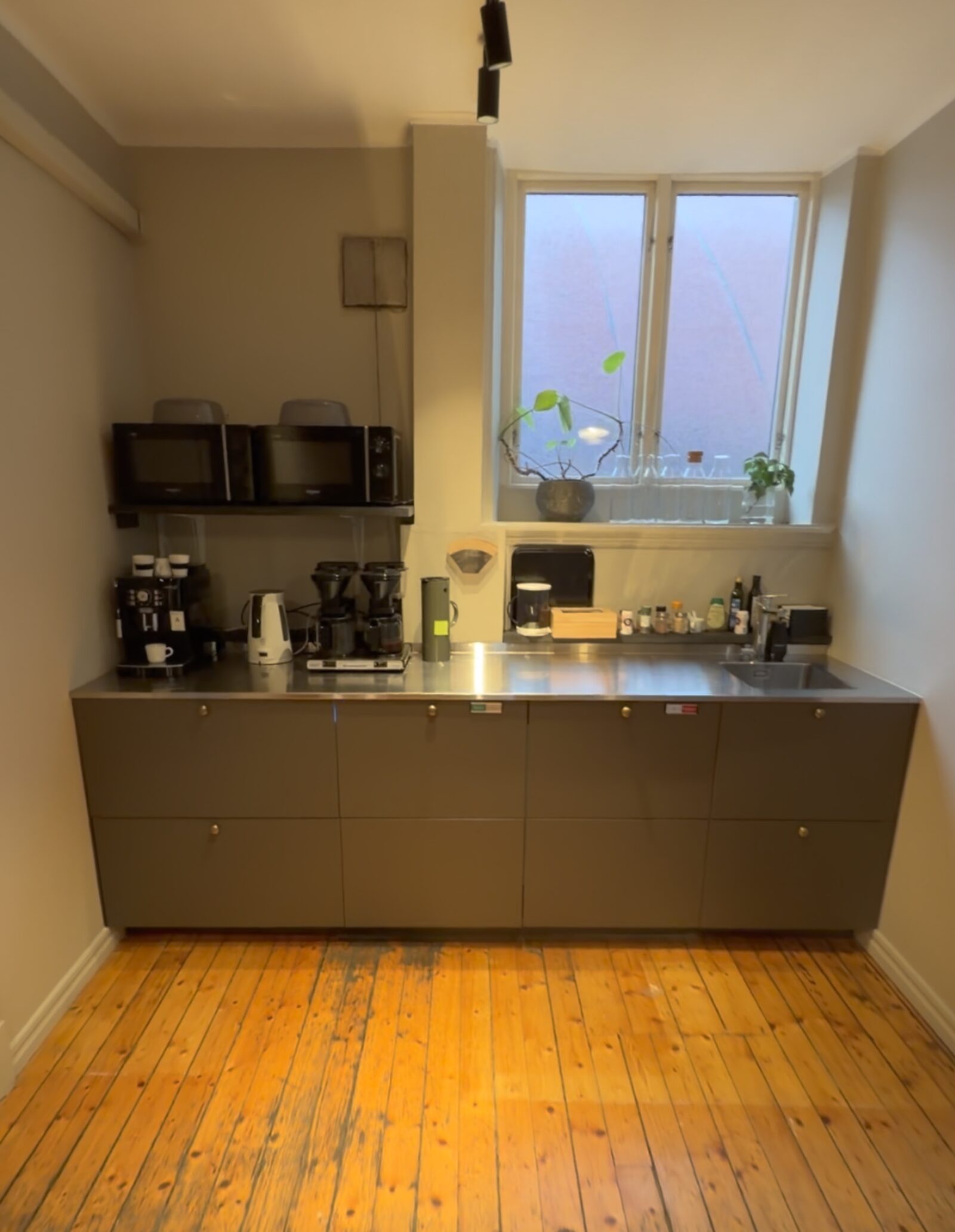 Gemensamt kök med kaffemaskiner och diskbänk